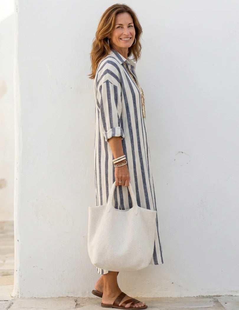 Detail van gestreepte midi shirtjurk met knoopsluiting en lange mouwen
